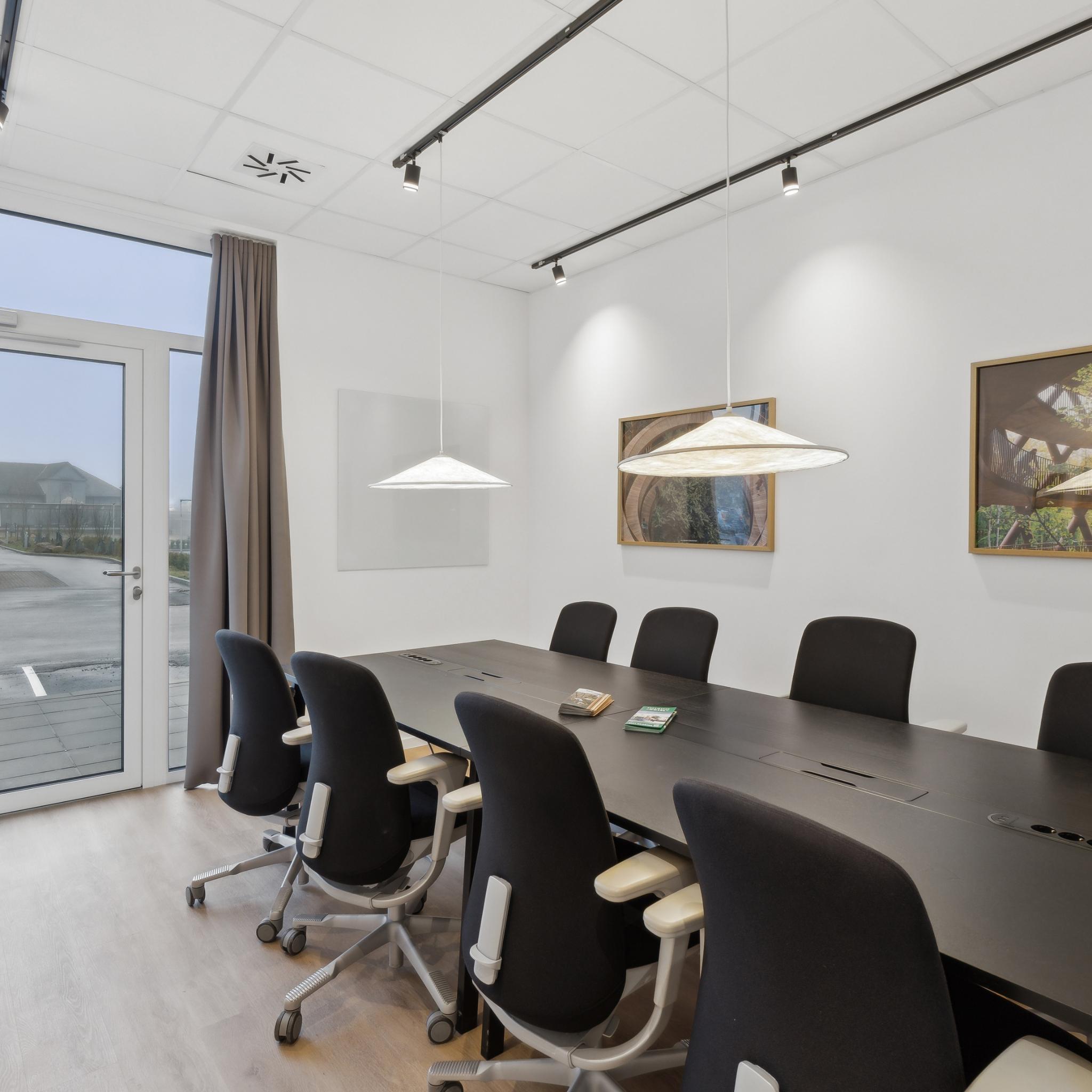 Lyst mødelokale på Easy Stay Hotel i Rønnede – moderne indretning med komfortable stole og dagslys.