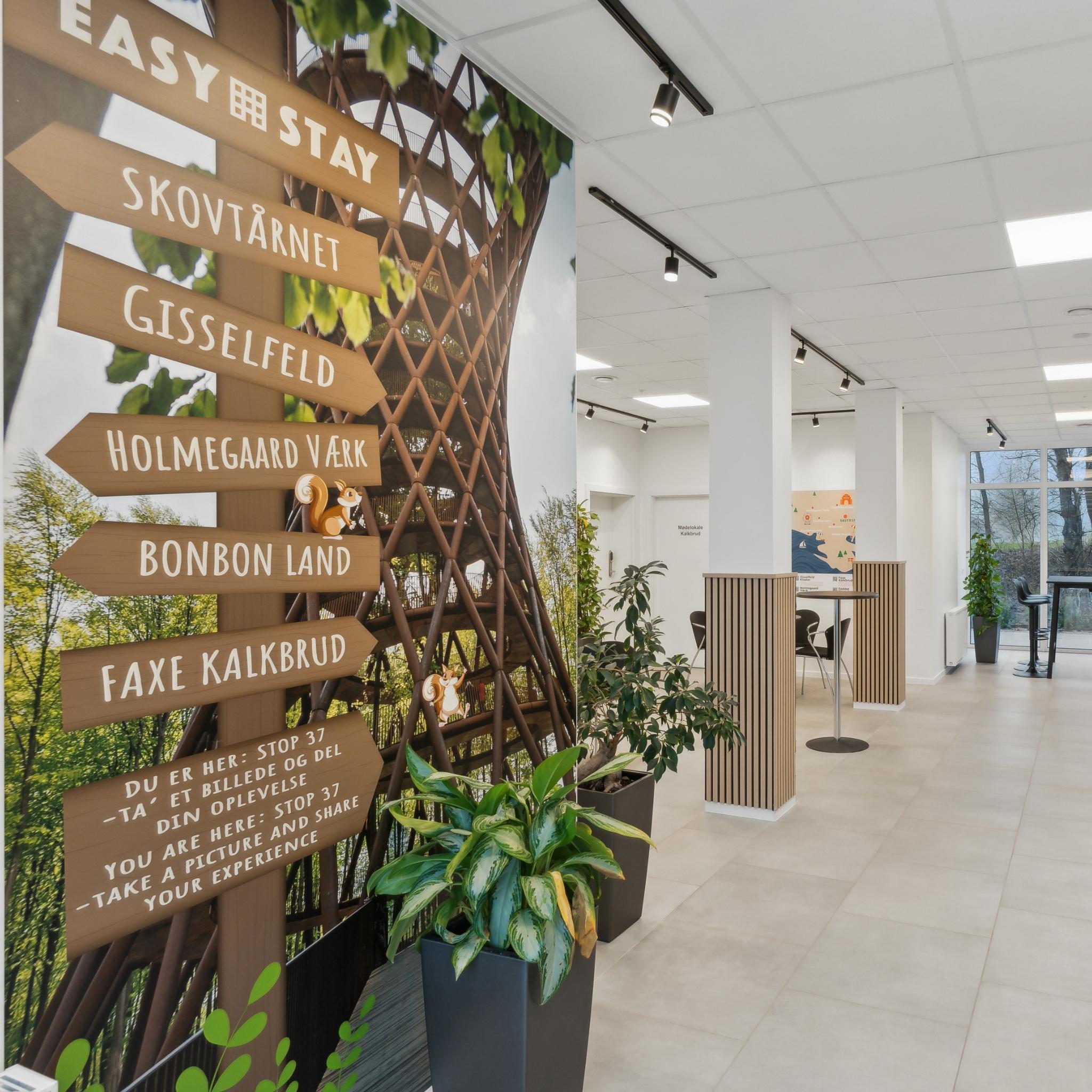 Velkomstområde på Easy Stay Hotel Rønnede med vægkunst og henvisninger til lokale attraktioner